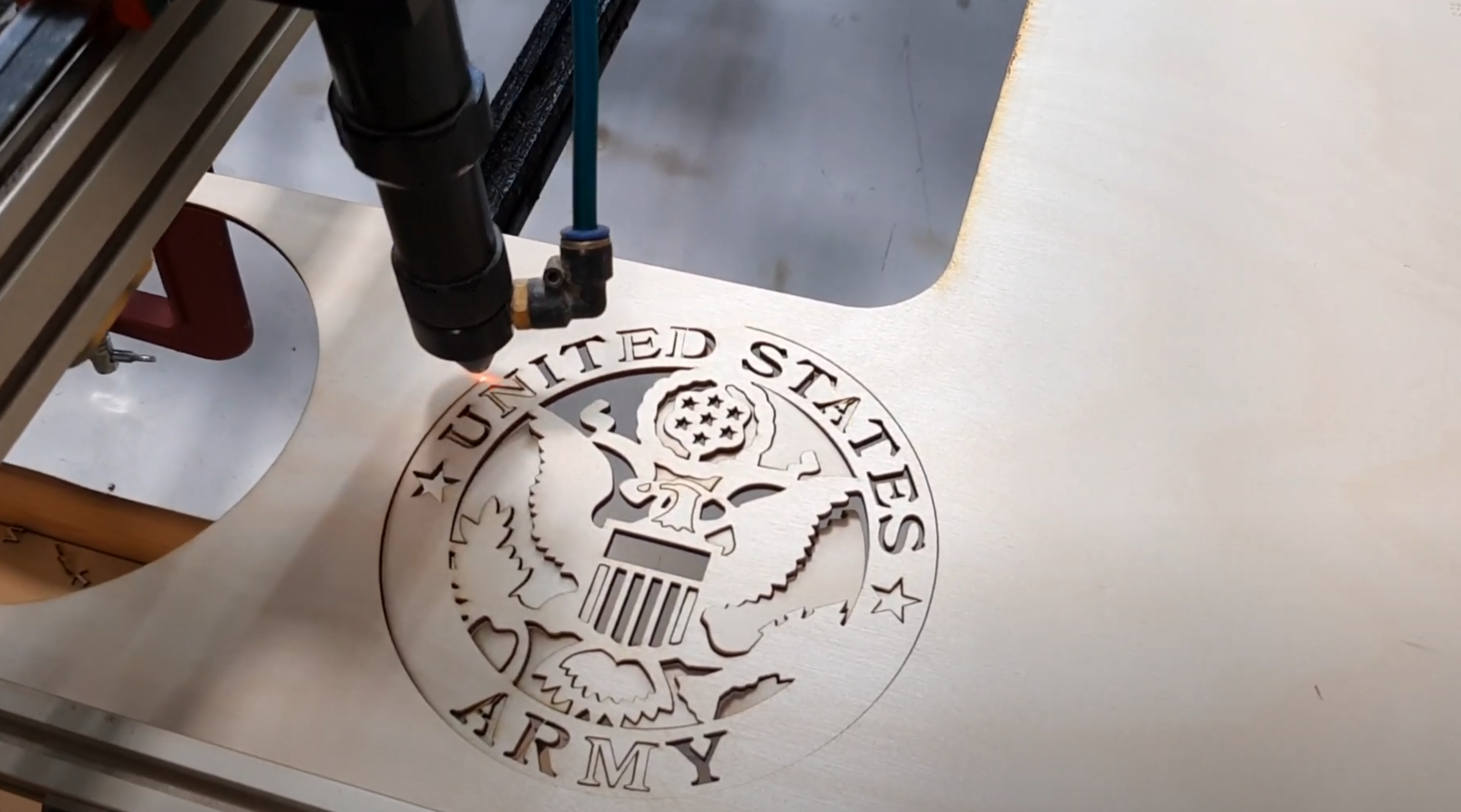 Load video: Custom laser cutting an army embellishment for a wood flag